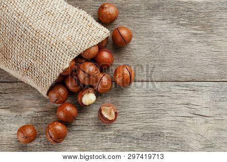Macadamia Nut On A Wooden Table In A Bag, Closeup, Top View