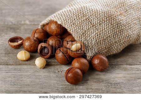 Macadamia Nut On A Wooden Table In A Bag, Closeup, Top View
