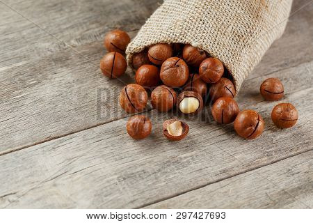 Macadamia Nut On A Wooden Table In A Bag, Closeup, Top View