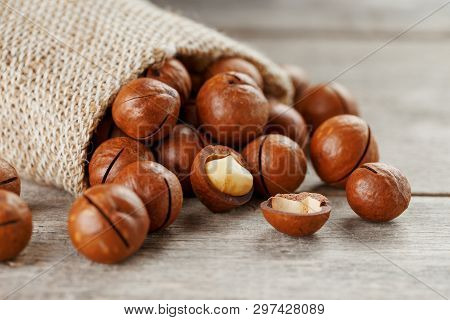 Macadamia Nut On A Wooden Table In A Bag, Closeup, Top View