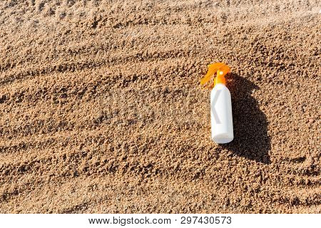 Suntan Lotion White Bottle On Sand With Copy Space. Sunblock Spf Cream On The Sea Beach In Summer Va