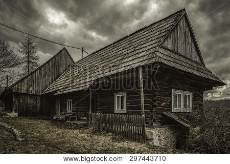Old Cottage In Village Velke Borove And Dark Clouds Over, Slovakia