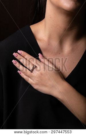 Womens Silver, Twisted The Ring On Her Finger, On Black Background.