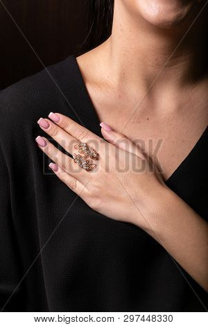 Womens Ring In Rose Gold In The Form Of Leaves With Stones On The Finger, On A Black Background.