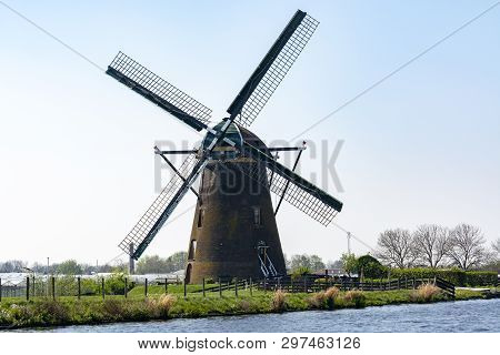 Traditional Dutch Wind Mill Built Along The Canal In North Holland, Spring Landscape