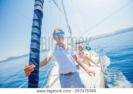 Little Boy With His Mother Having Fun On Board Of Yacht On Summer Cruise. Travel Adventure, Yachting