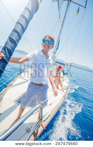 Little Boy With His Mother Having Fun On Board Of Yacht On Summer Cruise. Travel Adventure, Yachting