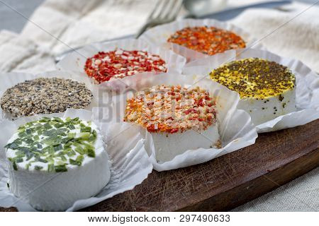Assortment Of French Fresh White Soft Goat Cheeses With Different Tastes Topping Made With Herbs, Pa