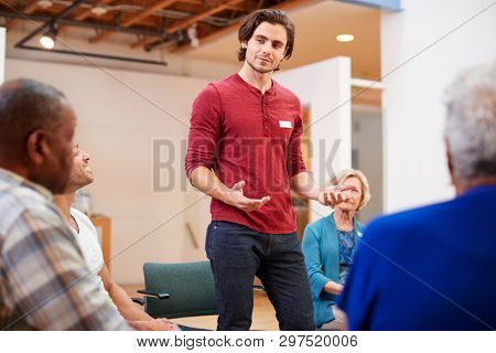 Man Standing To Address Self Help Therapy Group Meeting In Community Center