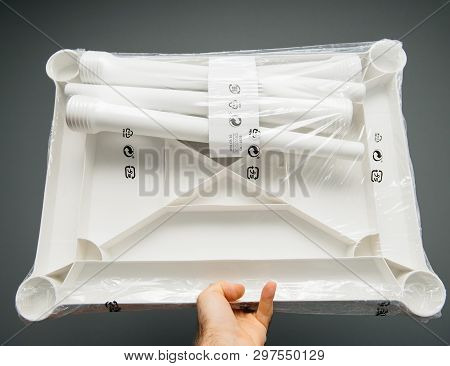 Paris, France - Apr 16, 2019: Man Hand Holding Against Gray Background Ikea Plastic Utter Table Rear