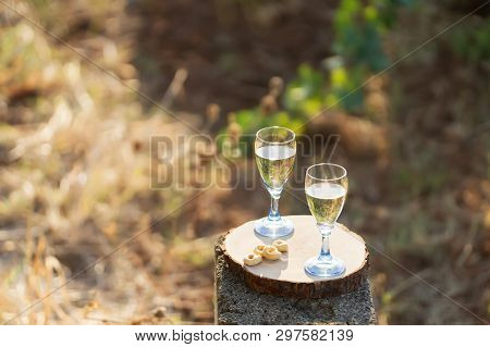 Two Glasses Of Fresh White Wine On A Wooden Board A Traditional Italian Snack - Taralli On A Bright 