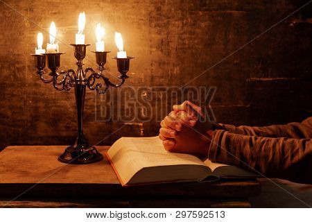 Religious Female Crossed Hands In Prayer With Bible And Candle, Christian Religion Practice