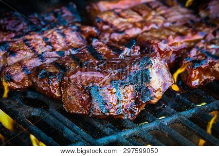 Boneless Beef Ribs Grilling Over Flames With Added Barbecue Sauce. Extreme Shallow Depth Of Field Wi