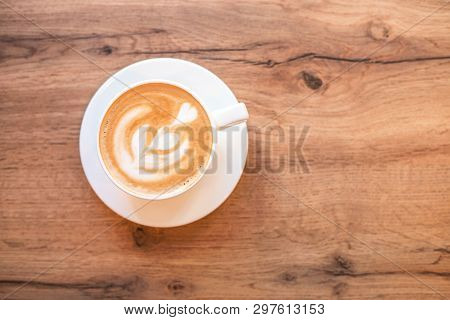 Cappuccino With Frothy Foam, Blue Coffee Cup Top View Closeup On White Wood Background. Flat Lay Sty