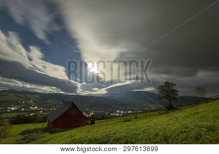 Summer Night Mountain Panorama. Small House Cottage On Steep Mountain Slope On Dramatic Evening Sky 