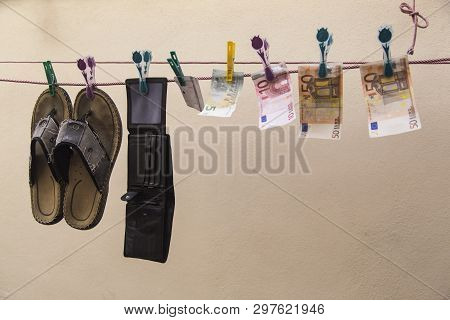 Shoes, A Wallet And Several Bills, All Wet, Hanging From A Washing Line.