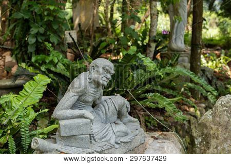 stone ruined Arhat statue in forest, Taiwan, Asia