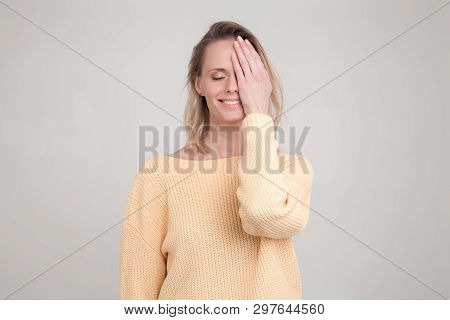 Portrait Of Happy Blonde Woman With Pleased Expression On Her Face, With Eyes Closed, Keeping Her Ha