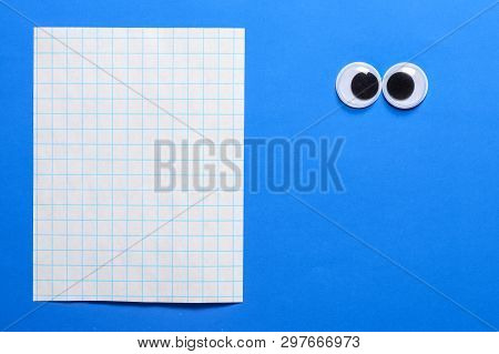 Cross-eyed Googly Eyes On Blue Paper Background With Copy Space For Your Text. Mad Funny Toys Eyes C