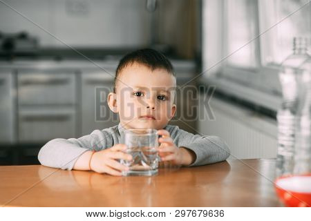 Portrait Of A Boy Drinking A Glass Of Water,happy In The Kitchen