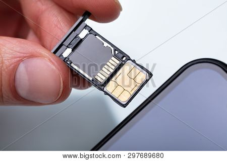 Person Inserting Sim Card In Cellphone