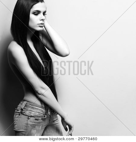Fotografie sexuální krasavicí v džínách, stojící nedaleko walll je v módní styl, kouzlo