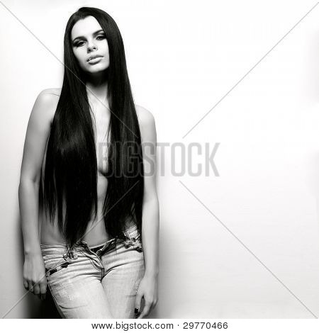 Fotografie sexuální krasavicí v džínách, stojící nedaleko walll je v módní styl, kouzlo