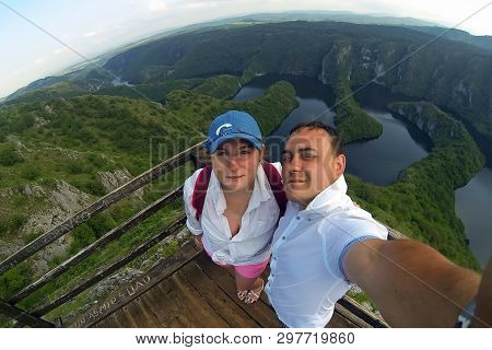 Young Couple Making Selfie Photo On The View Point. Top Of The Hill And Panorama Of Canyon Uvac In S