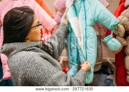 Future mother in the store for newborns, cloth