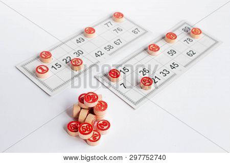 Bingo Or Lotto Game. Wooden Kegs Of Lotto On Cards. Cards And Chips For Playing Bingo On A White Tab