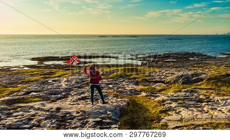 Tourist Woman With Waving Norwegian Flag Enjoying Sea Coast View On Rest Stop Area On Andoya Island 