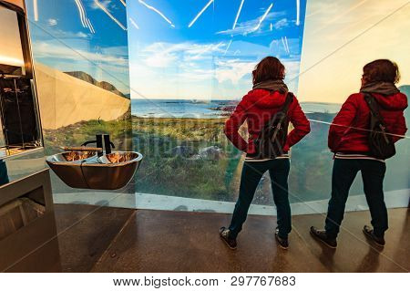 Tourist Woman Look Out At The Sea Coast Landscape From The Inside Of Mirrored Toilet Bukkekjerka Res