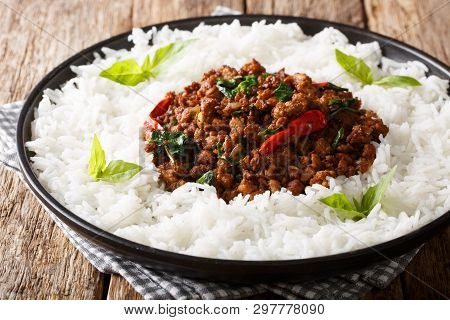 Stir Fry Basil Chicken With Chili Pepper And Soy Sauce With A Side Dish Of Rice Close-up On A Plate.