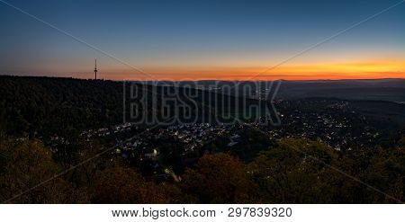 A Television Tower Surrounded By A Forest With A Sunset Sky In The Background. Seen From The Thick W