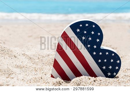 Patriotic Usa Background With American Flag Colored Heart On The Sandy Beach Near Ocean