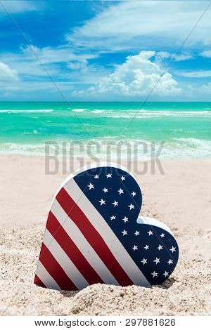 Patriotic Usa Background With American Flag Colored Heart On The Sandy Beach Near Ocean
