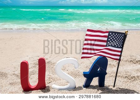Patriotic Usa Background With Flag On The Sandy Beach Near Ocean