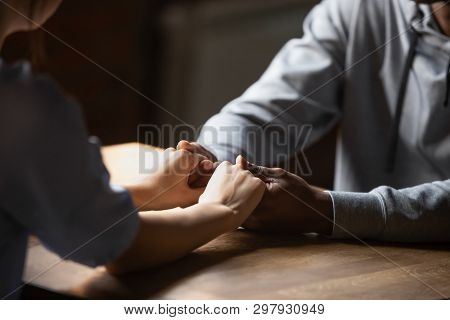 Close Up Hands Diverse Couple Sitting At Table Holding Hands