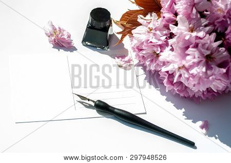 Old Ink Pen And Ink Bottle On White Background. Vintage Calligraphy Pen And Bottle Of Ink. Selective
