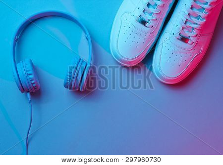 Sneakers With Wireless Headphones. Retro Wave, Neon Light, Ultraviolet. Top View, Minimalism