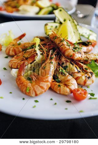 Hele grillede friske rejer og grøntsager serveres på et osteria restaurant i Venedig, Italien