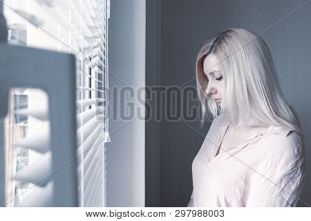 Sad Apathetic Lonely Woman Looking Through A Window At Home Or Hotel, Divorce, Depression And Apathy