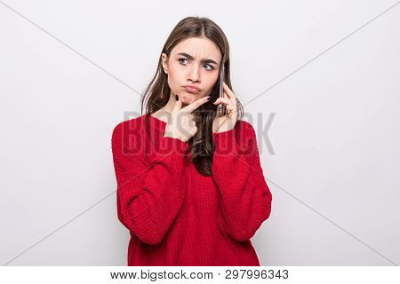 Portrait Of Thoughtful Doubtful Woman Talking On Mobile Phone And Looking Up Isolated Over White Bac