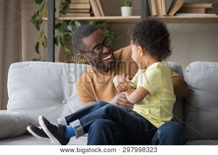 African Father Tickling Little Adorable Son Having Fun At Home