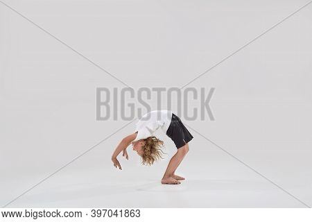 Full Length Shot Of Little Playful Boy Child Standing In Bridge Pose, Bending Over Backwards Isolate