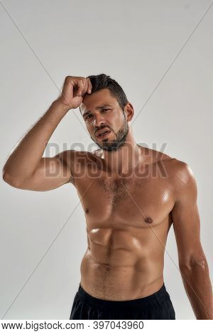 Strong And Powerful. Young Tired Caucasian Bodybuider Standing With Hand Near Head And Looking At Ca
