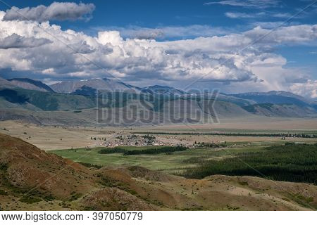A Small Village In The Chui Valley Between The Mountains. White Clouds On A Blue Sky, Altai.