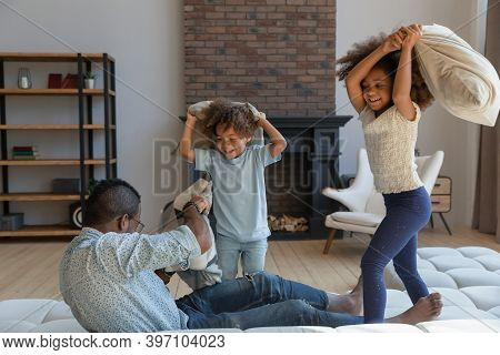 Laughing Black Dad Taking Part In Active Game With Children