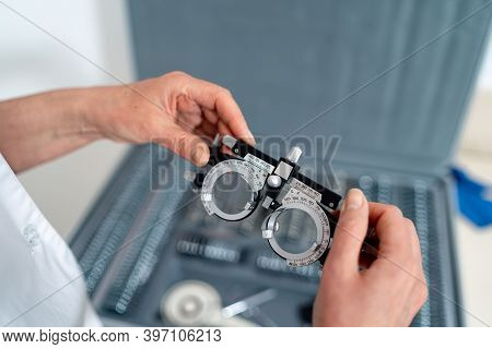 Medical Device For Examining Eyesight Of Patient. Woman Holding Ophthalmology Glasses.