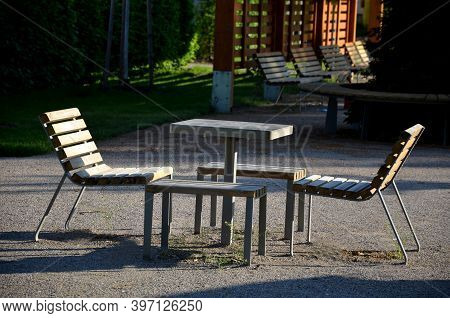 Park Furniture Chess Table And Chairs For Four Persons Made Of Light Metal And Wooden Beams With Bac
